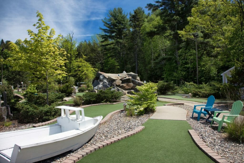 Golfers crossing mini golf in rockport maine - showing boat and course for mini golf